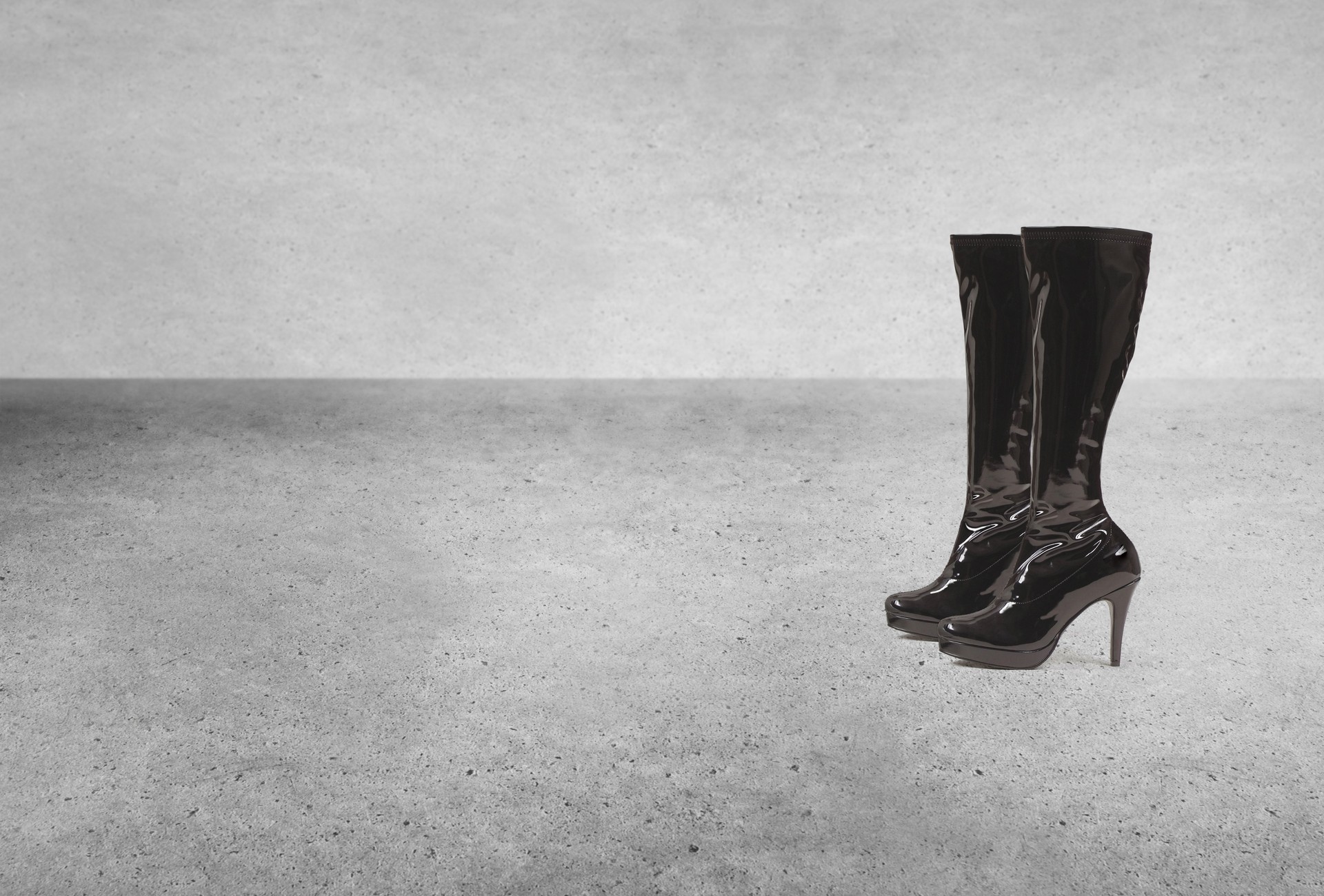 Sexy black thigh high leather boots in a basement