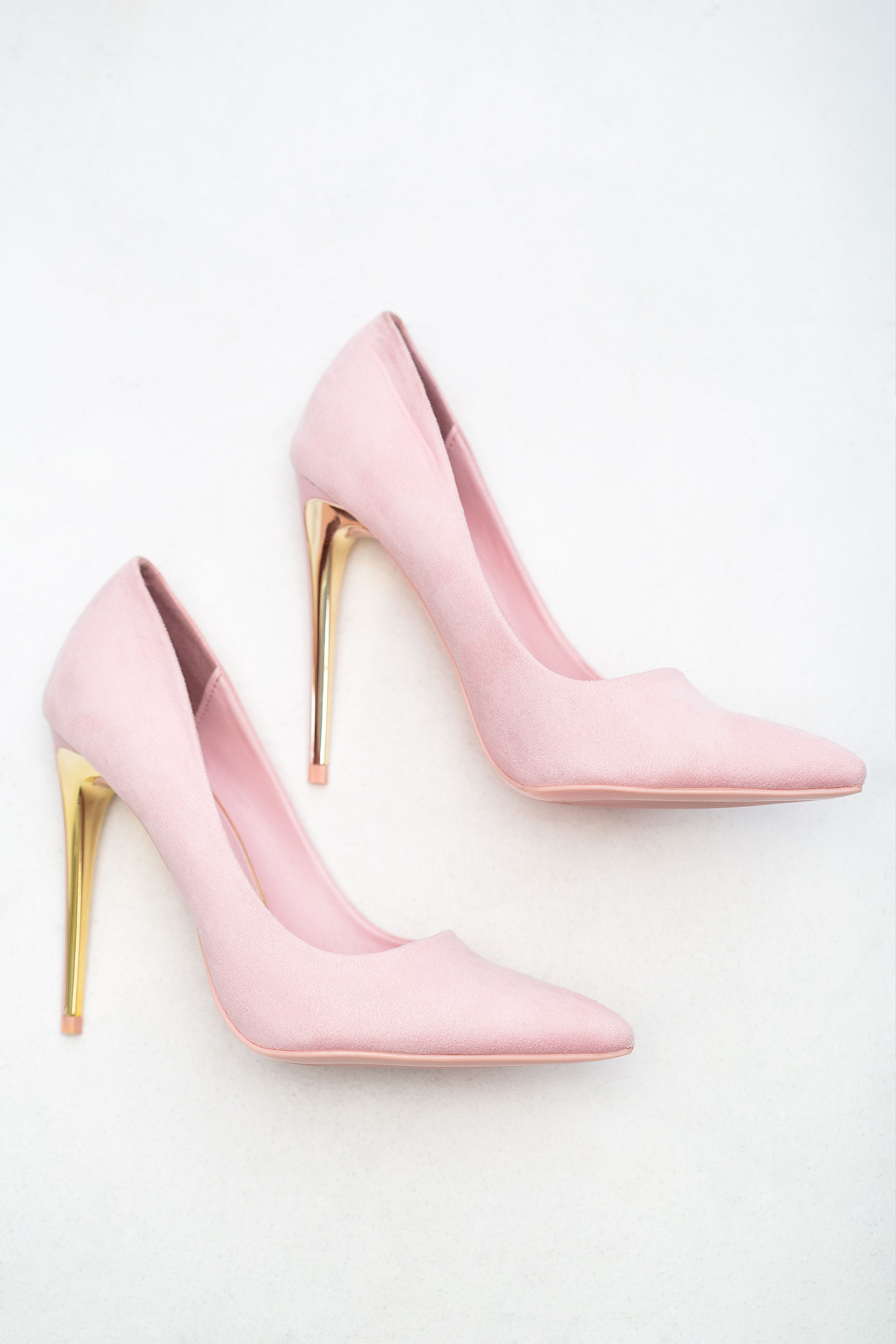 Pink shoes with gold high heels on white background